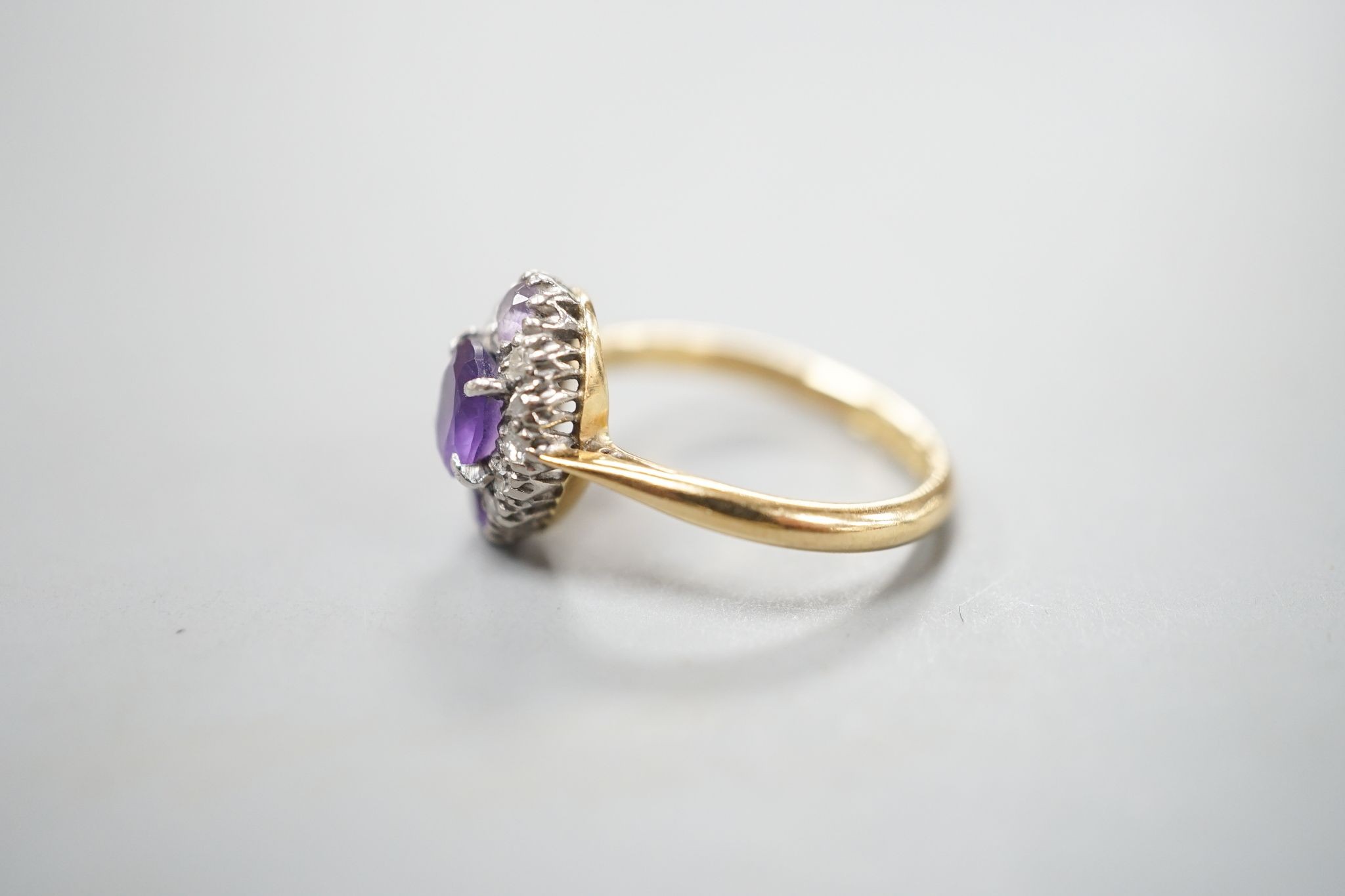 An early 20th century 18ct & plat, amethyst and diamond set marquise cluster ring, size K, gross weight 3.2 grams.